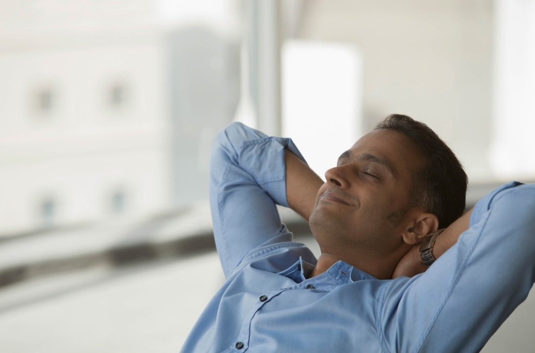 Man relaxing with his hands behind his head — preparing calmly for surgery